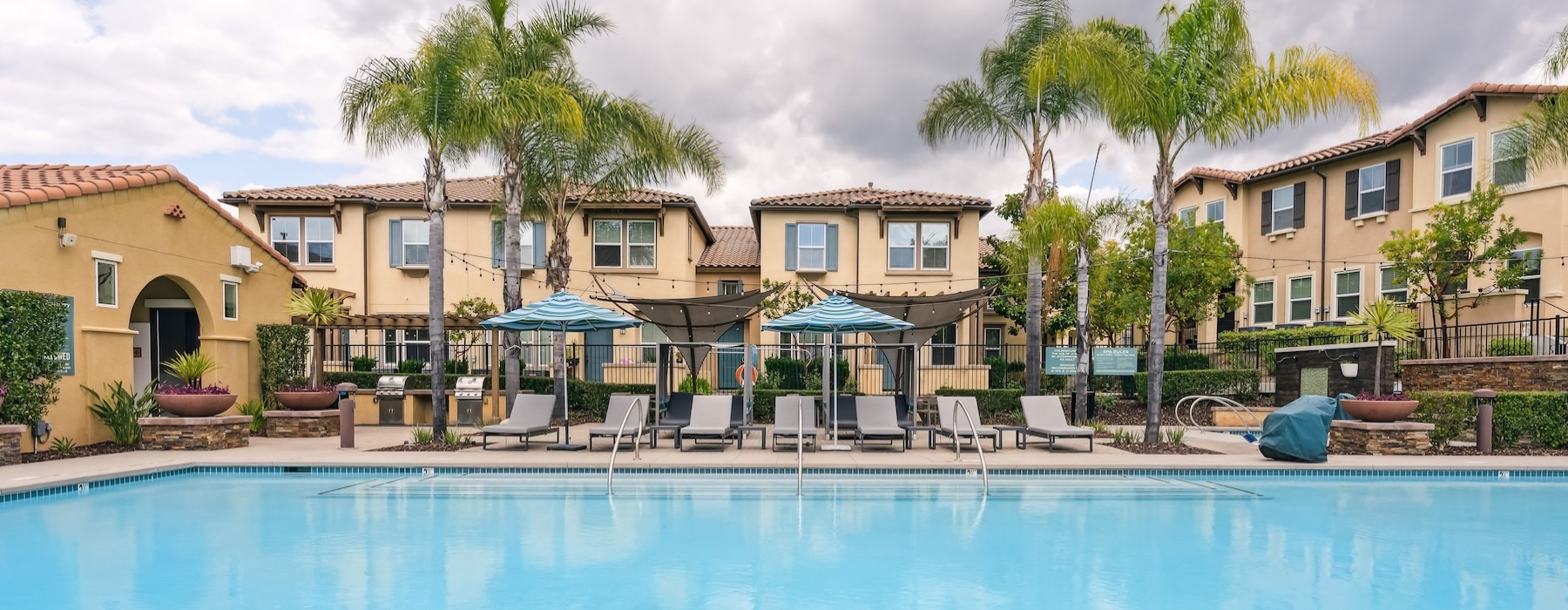a swimming pool with lounge chairs and palm trees